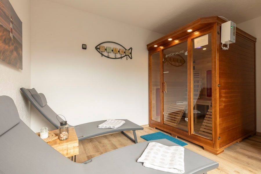 Ein Raum mit Sauna, Liegestühlen und einem Fisch an der Wand.