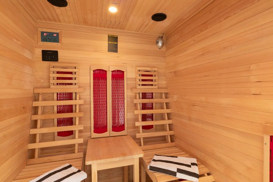 Eine Infrarotkabine mit einem Tisch und Stühlen darin.