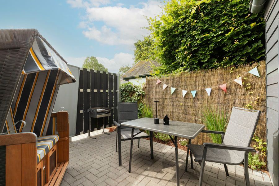 Auf der Terrasse im Hinterhof gibt es einen Tisch und Stühle.