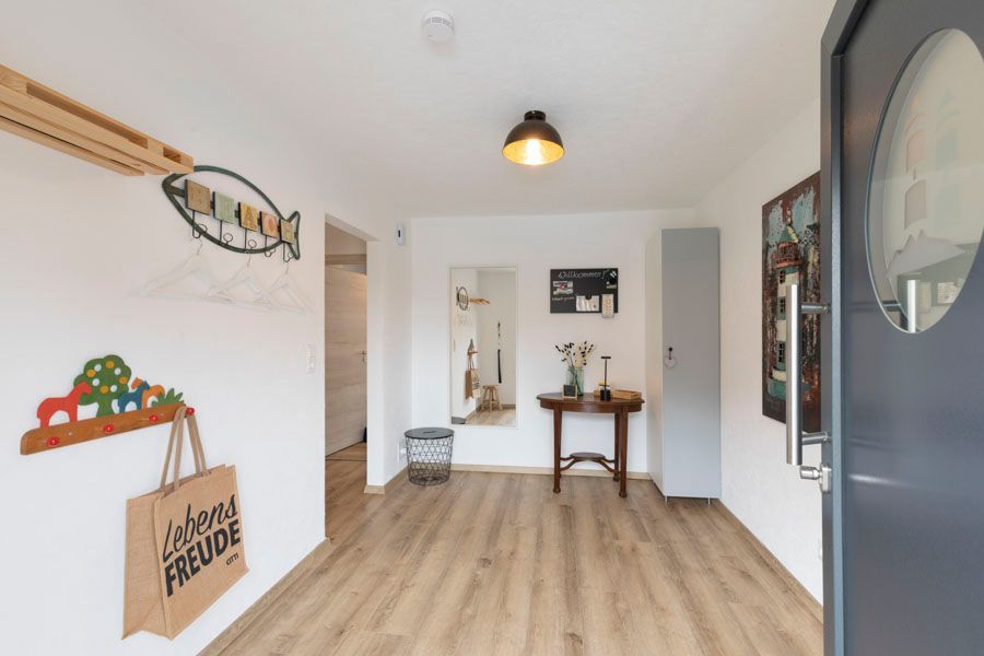 Ein Flur mit Holzboden und einer grauen Tür.