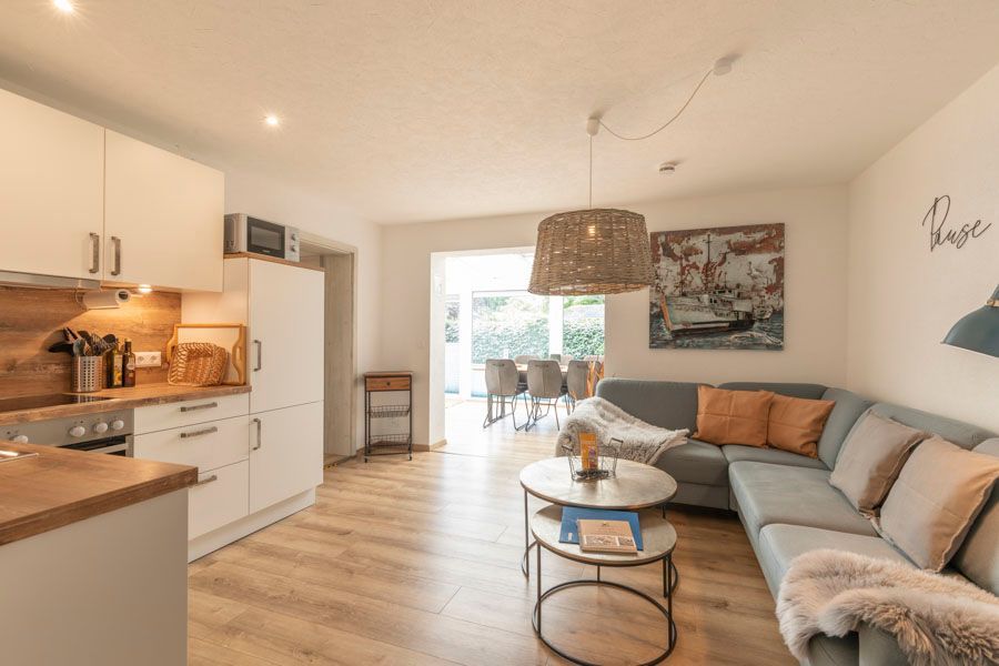 Ein Wohnzimmer mit Couch, Couchtisch und Küche.