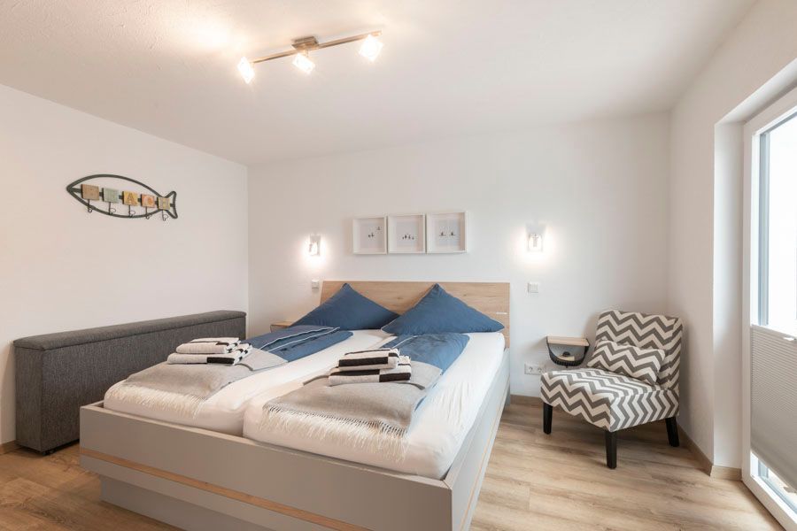 Ein Schlafzimmer mit Bett, Stuhl und Fenster.