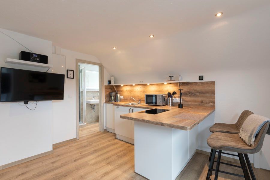 Eine Küche mit Bar und Flachbildfernseher.