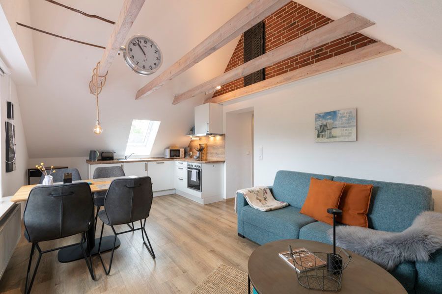 Ein Wohnzimmer mit einem blauen Sofa und einer Uhr an der Decke.