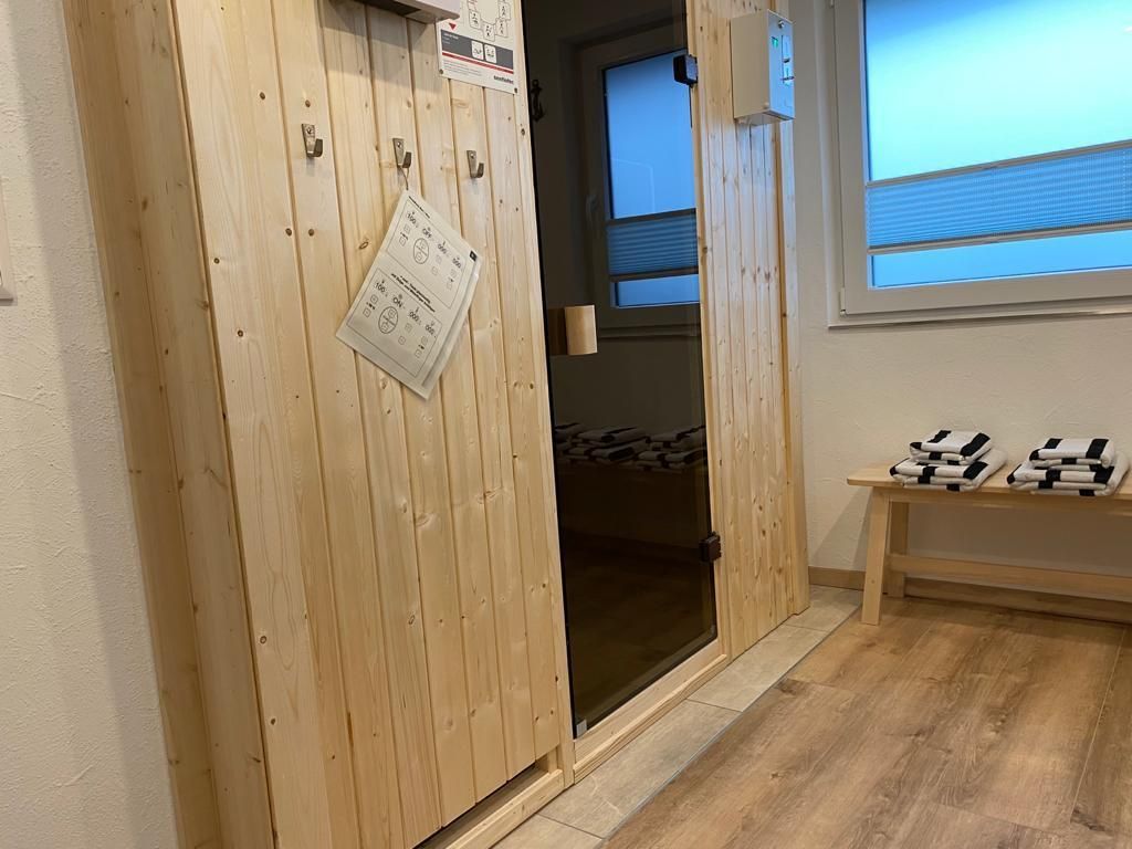 Ein Raum mit einer Holztür, die zu einem Schlafzimmer führt.