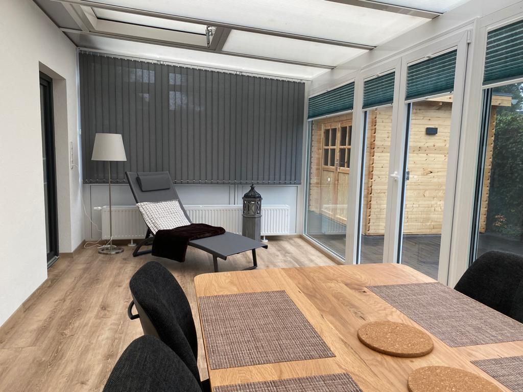 Ein Wohnzimmer mit einem Tisch, Stühlen und einer Lampe.