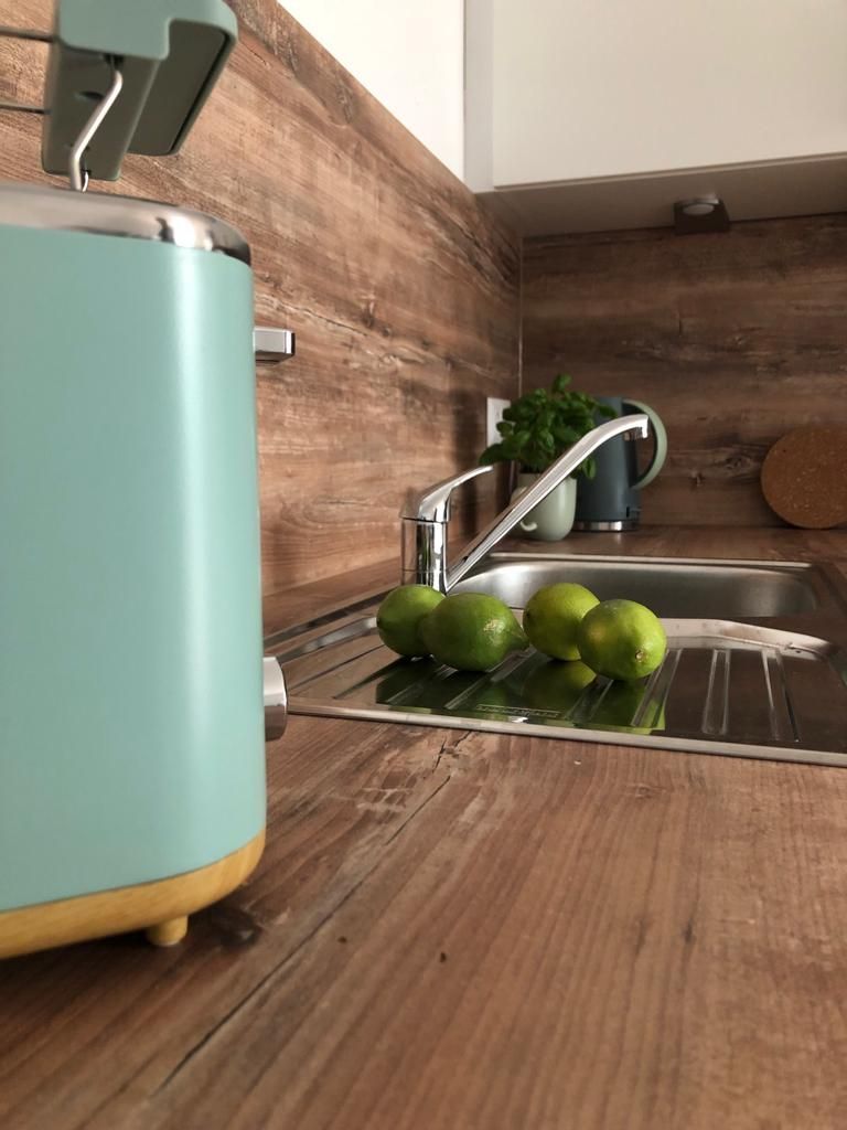 Eine Küche mit Spüle, Toaster und Limetten auf der Anrichte.