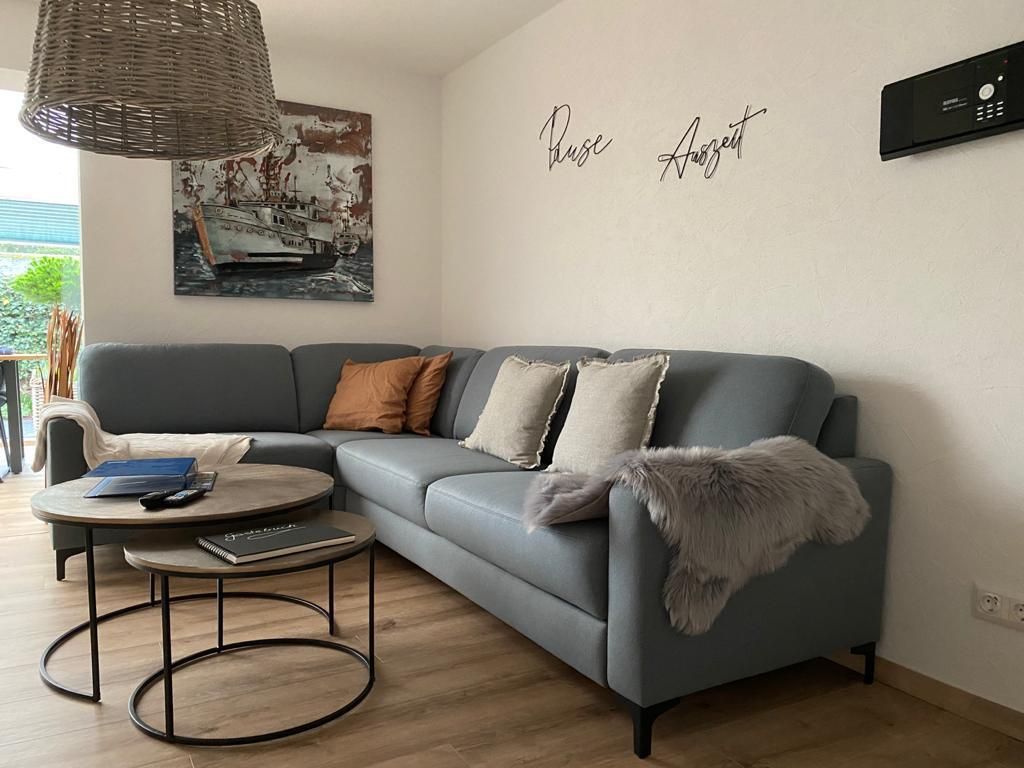 Ein Wohnzimmer mit einer Couch, zwei Couchtischen und einem Gemälde an der Wand.