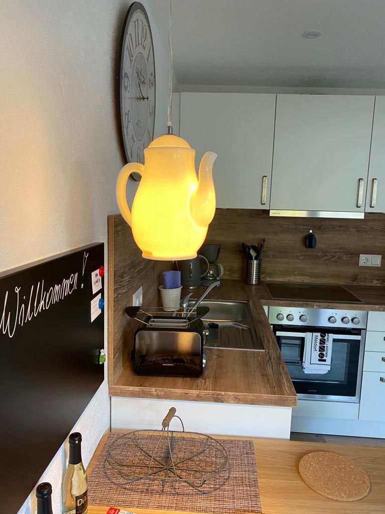 Eine Küche mit einer gelben Teekanne, die von der Decke hängt