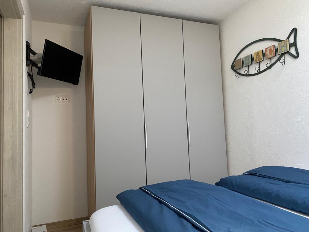 Ein Schlafzimmer mit zwei Betten und einem Fernseher an der Wand.