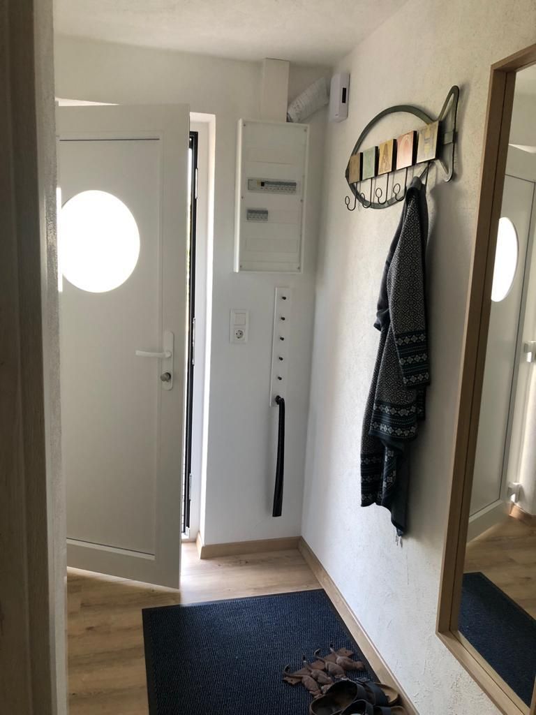 Ein Flur mit Garderobe und Spiegel.