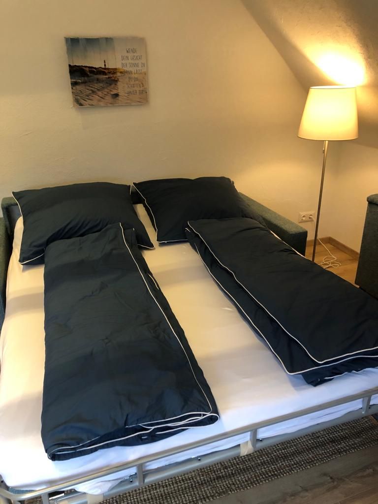Ein Schlafzimmer mit zwei Betten, einer Couch und einer Lampe.