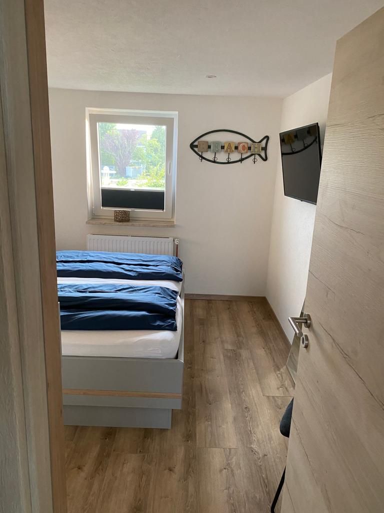 Ein Schlafzimmer mit einem Bett und einem Fernseher an der Wand.