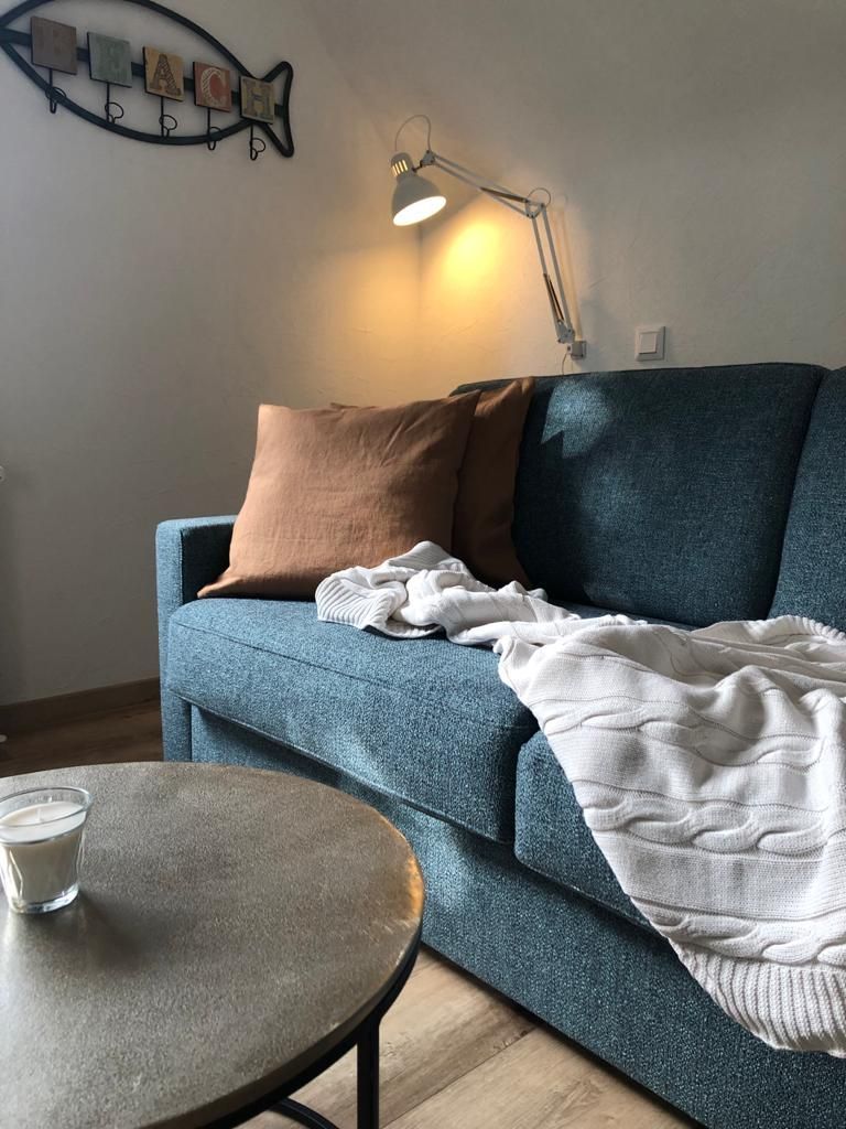 Ein Wohnzimmer mit einer blauen Couch und einem runden Tisch.