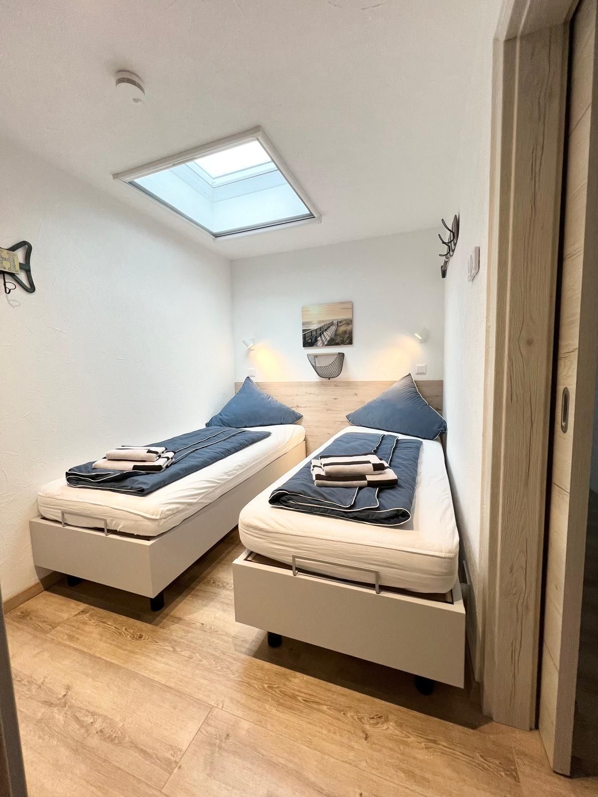 Ein Schlafzimmer mit zwei Betten und einem Oberlicht in der Decke.