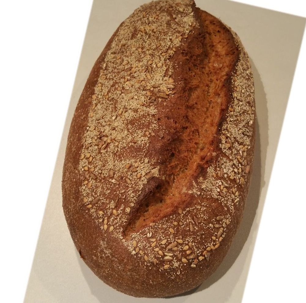 Ein Laib Brot liegt auf einer weißen Fläche.