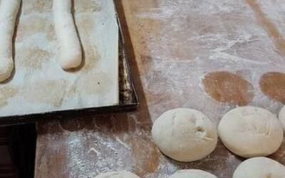 Ein Haufen Teig liegt auf einem Tisch neben einem Tablett mit Teig.