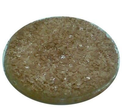 Ein runder Behälter, gefüllt mit einer braunen Substanz auf weißem Hintergrund.