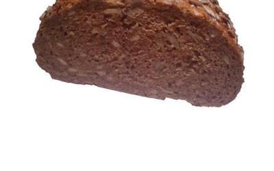 Ein Stück Schokoladenkuchen liegt auf einer weißen Fläche.