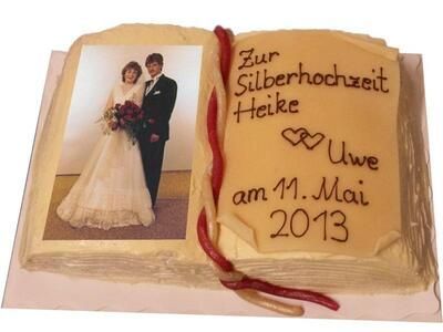 Ein Kuchen in Buchform mit einem Bild von Braut und Bräutigam darauf