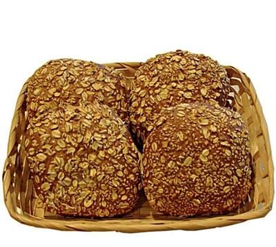 Vier Haferflockenbrötchen in einem Korb auf weißem Hintergrund