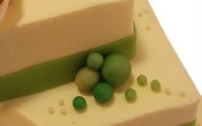 Ein weißer Kuchen mit grünen Kugeln und Perlen darauf