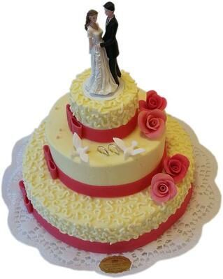 Eine Hochzeitstorte mit einer Braut- und Bräutigamfigur obenauf