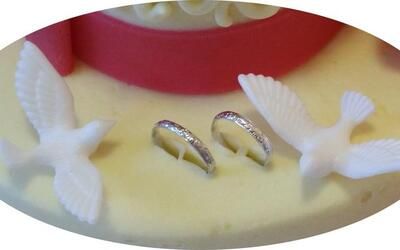 Eine Hochzeitstorte mit zwei Ringen und zwei Tauben darauf