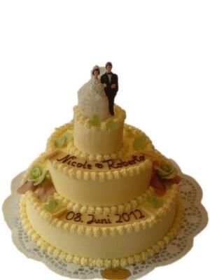 Eine Hochzeitstorte mit einer Braut- und Bräutigamfigur obenauf