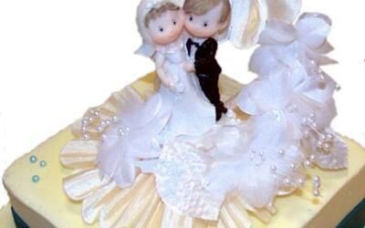 Eine Hochzeitstorte mit einer Braut- und Bräutigamfigur darauf.