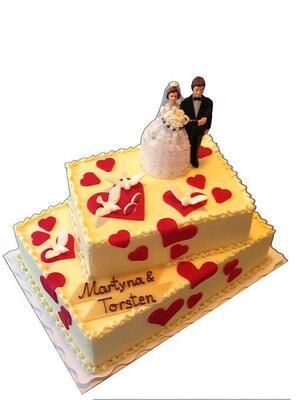 Eine Hochzeitstorte mit einer Braut- und Bräutigamfigur obenauf
