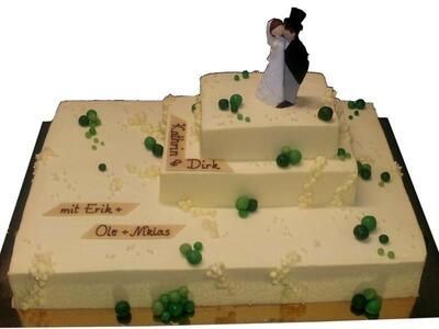 Eine Hochzeitstorte mit Braut und Bräutigam oben drauf