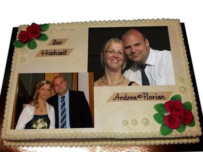 Eine Hochzeitstorte mit einem Bild von Braut und Bräutigam darauf