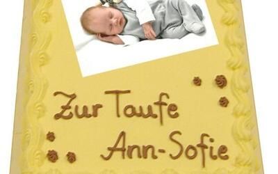 Ein gelber Kuchen mit einem Babybild darauf.