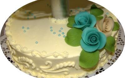 Ein Kuchen mit blauen Rosen und grünen Blättern darauf