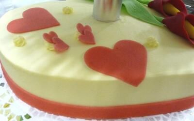 Ein weißer Kuchen mit roten Herzen darauf