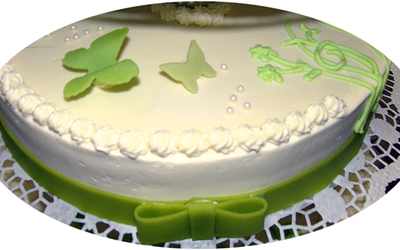 Ein weißer Kuchen mit grünen Schmetterlingen und Blumen darauf