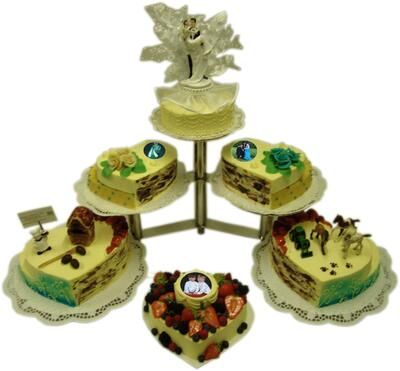 Eine Auswahl herzförmiger Kuchen mit Braut und Bräutigam oben drauf