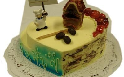 Ein herzförmiger Kuchen mit einer Kochfigur darauf.