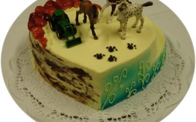 Ein herzförmiger Kuchen mit Pferden und einem Hund obendrauf