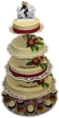 Eine Hochzeitstorte mit einer Braut- und Bräutigamfigur darauf.