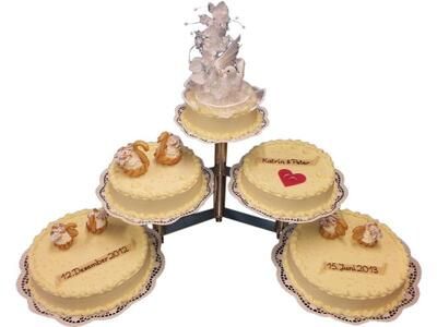 Vier Kuchen sind übereinander auf einem Ständer gestapelt