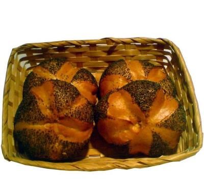Vier Mohnbrötchen in einem Korb auf weißem Hintergrund