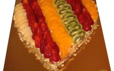 Ein herzförmiger Kuchen mit Früchten darauf