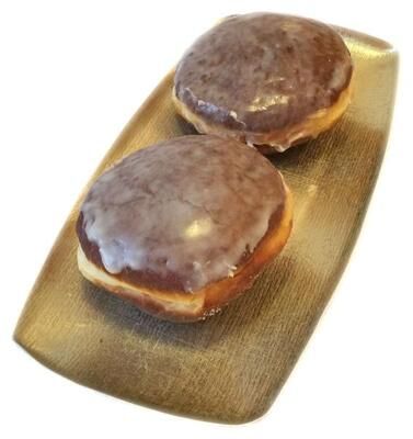 Zwei Donuts mit Schokoladenglasur auf einem goldenen Teller