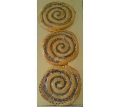 Drei Zimtschnecken liegen übereinander auf einem Tisch.