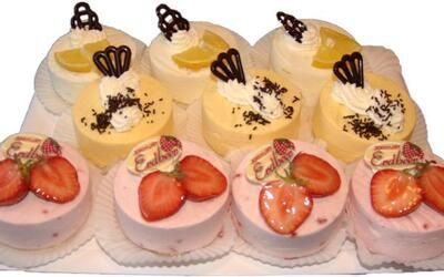 Ein Tablett mit Kuchen mit Erdbeeren und Zitronen darauf