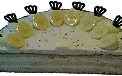 Ein Kuchen mit Bananenscheiben und Schokoladenkrönchen obenauf