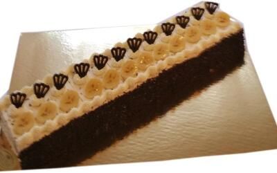 Ein langes Stück Schokoladenkuchen mit Bananen obendrauf