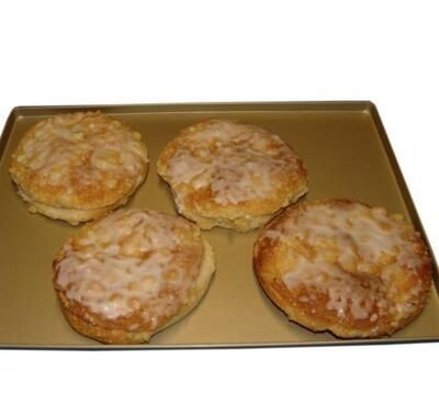 Vier Gebäckstücke mit Zuckerguss auf einem Tablett